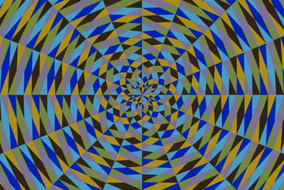 Radiating pattern of triangles arranged in a large quadrilateral, with pattern of blue pea green mustard and brown. The pattern is offsets tends to suggest a spiral.