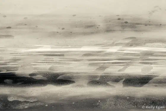 Warm grey tones fill the image with white streaks running horizontally through the center, interupted by splotches of grey the bottom is is darker than the top